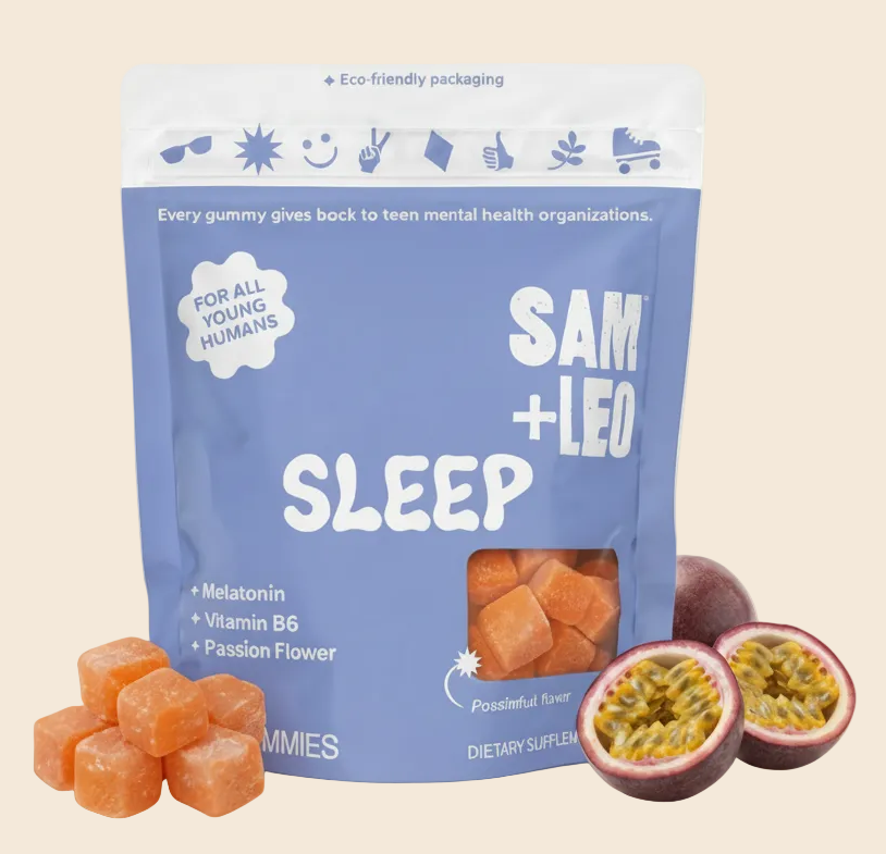 A stand-up pouch of SAM + LEO SLEEP gummies, featuring orange-colored gummy cubes in a clear window and fresh passionfruit and berry garnish on a white background.